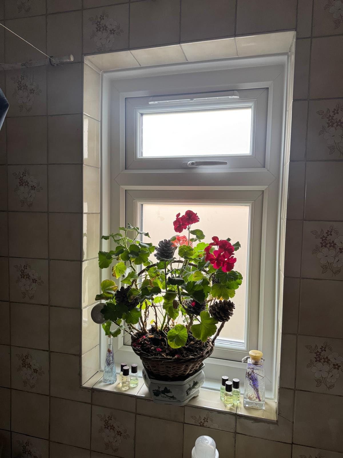 A white sliding sash window with Georgian bars in a tiled bathroom