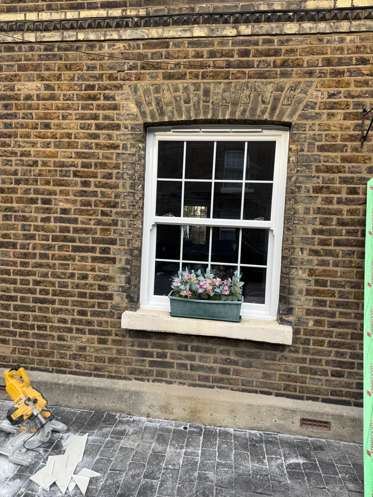 Sliding sash window with Georgian bars and a window box, London terrace