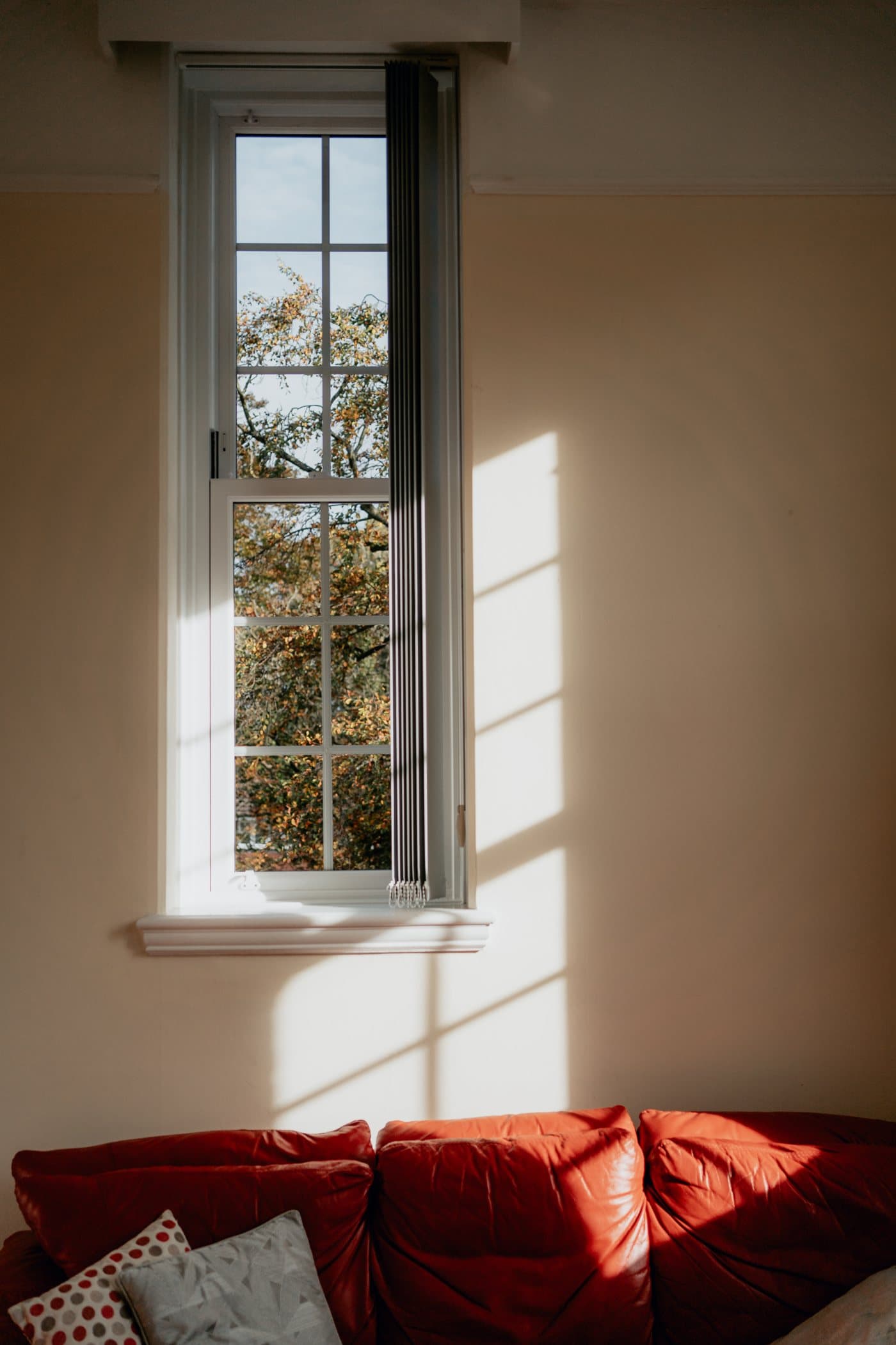 Autumn light through a sliding sash window into a warm room
