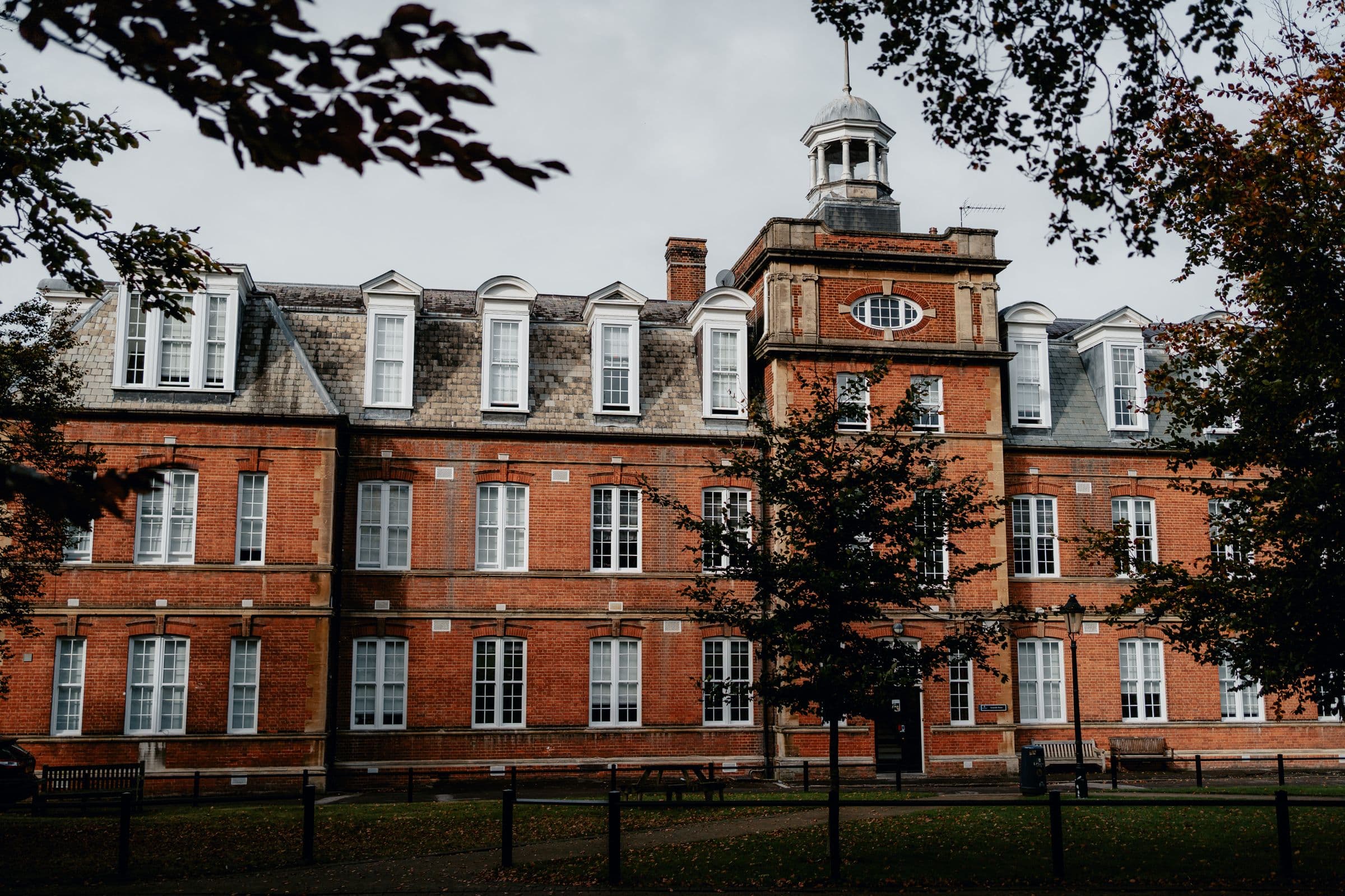 A period red-brick building with white sliding sash windows across every floor